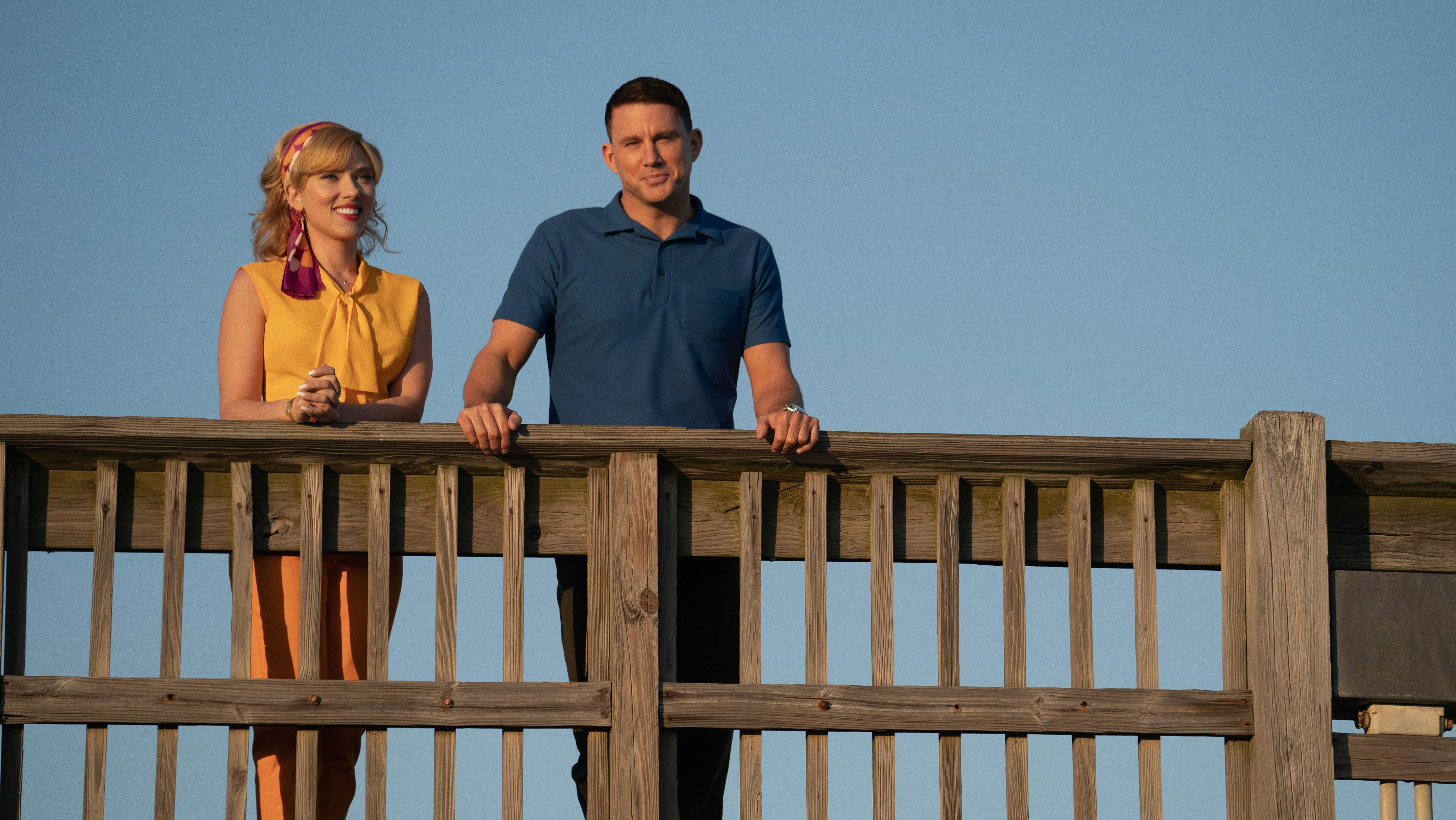 An image from the film Fly Me to the Moon. It features a man (Channing Tatum) and a woman (Scarlett Johannson) standing on a raised walkway.