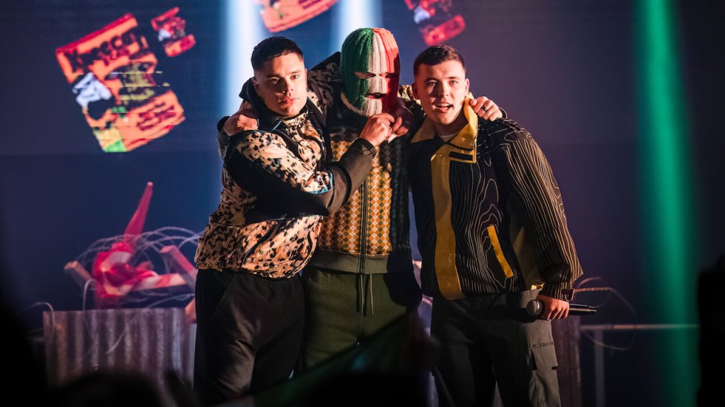 An image from the film Kneecap. It features the group performing on stage.