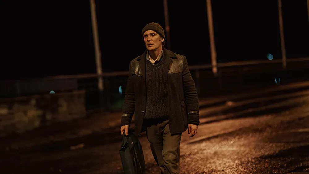 An image from the film Small Things Like These. It features a man (Cillian Murphy) walking along a street at nighttime.
