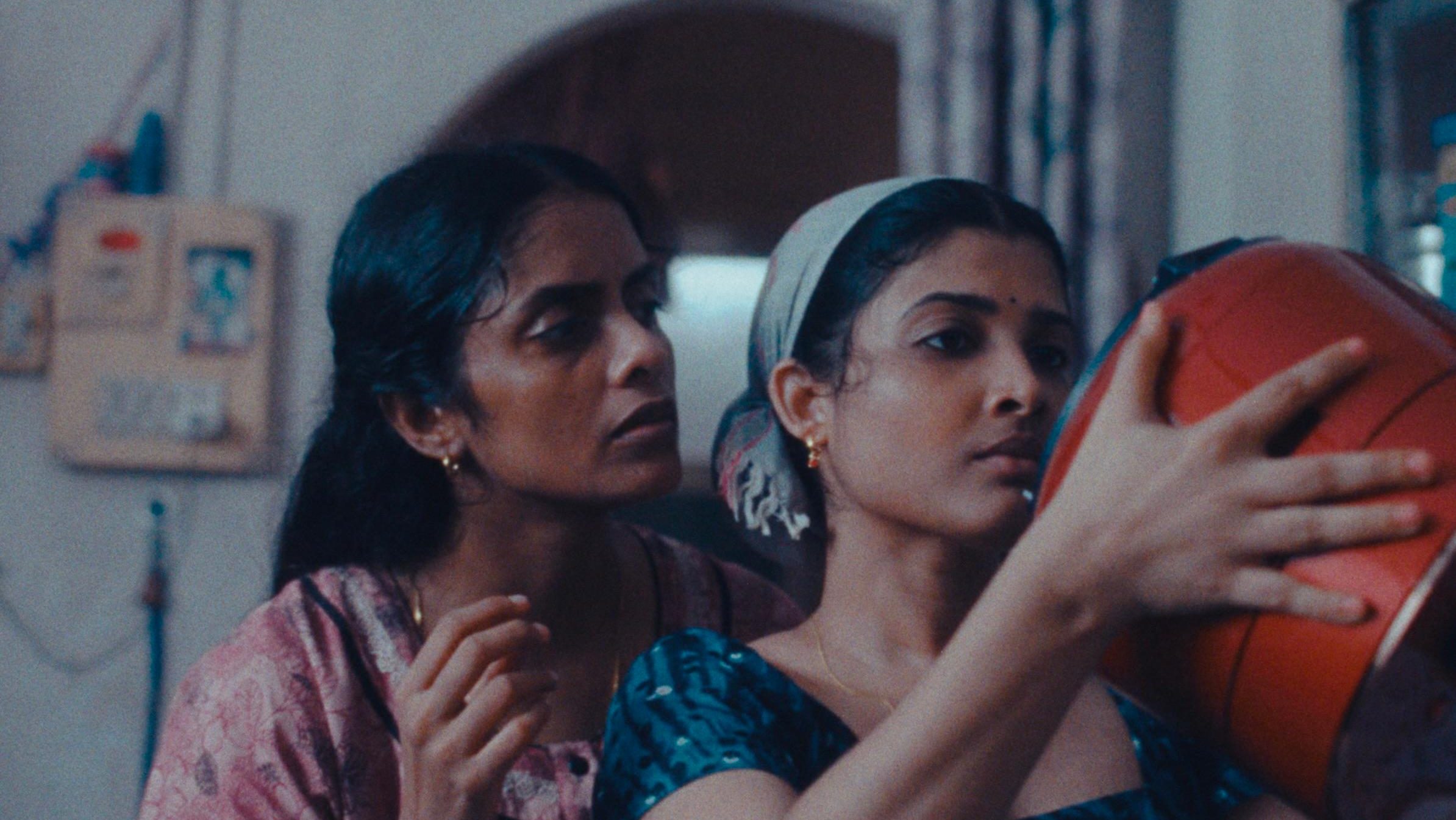 An image from the film All We Imagine as Light. It features two women (Kani Kusruti and Divya Prabha) looking at a rice cooker. 