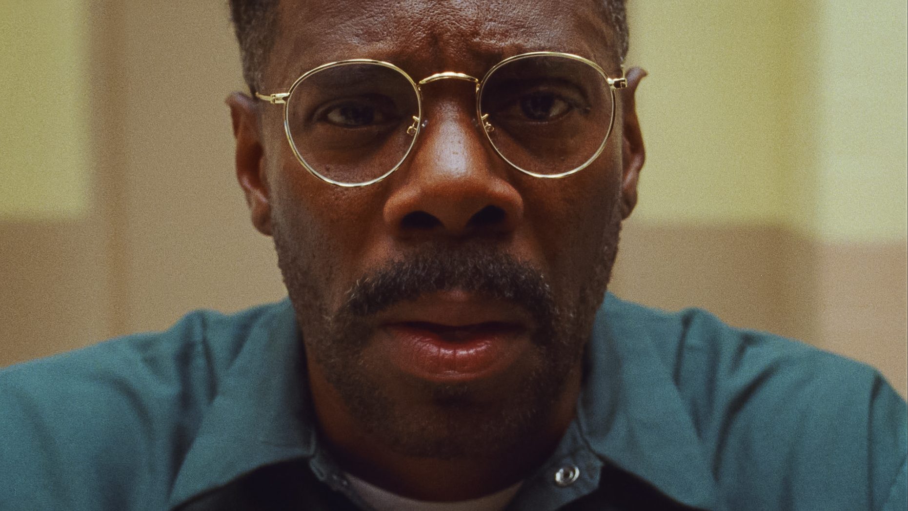An image from the film Sing Sing. It features a close up of a man (Colman Domingo) in prison wearing glasses. 
